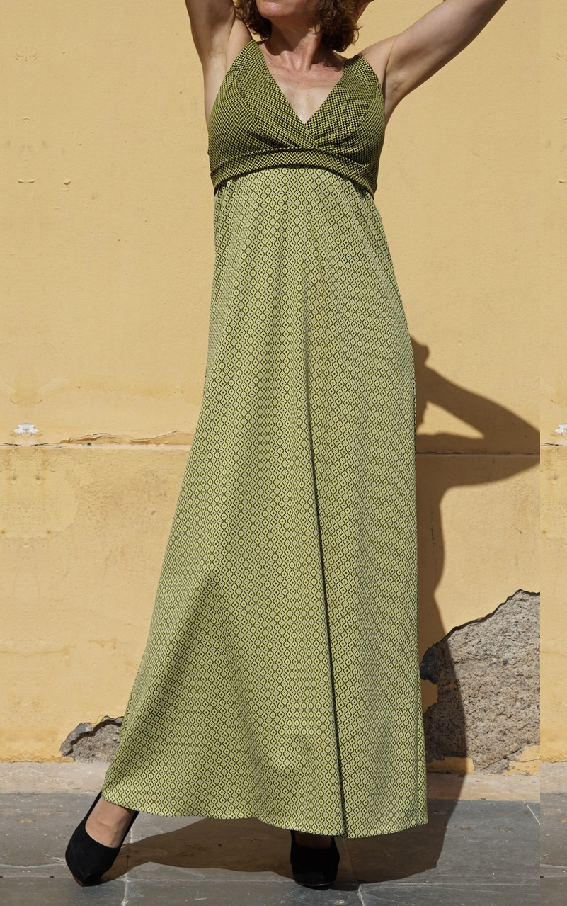 Vestido de cóctel largo de EVA TYCHÉ con dos estampados geométricos en verde y negro, escote cruzado en V y banda bajo el pecho. / Long cocktail dress by EVA TYCHÉ featuring two geometric prints in green and black, a crossover V-neckline and a band below the bust.